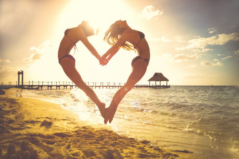 pretty women on the beach making a heart