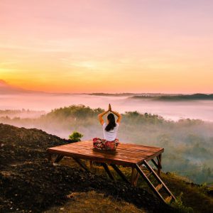 woman in a yoga pose on mountain top