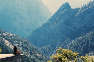 woman meditating on a cliff